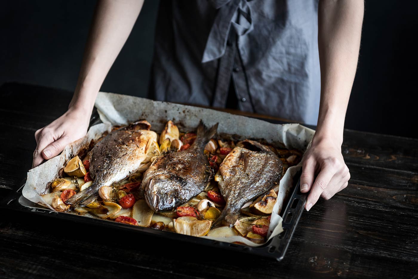 Baked fish being placed on table